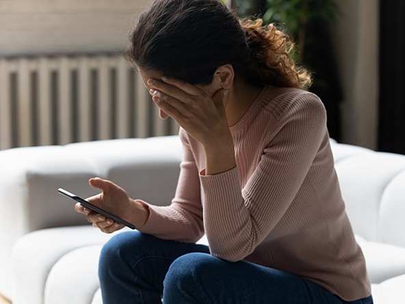 young woman stressed and upset by text message 